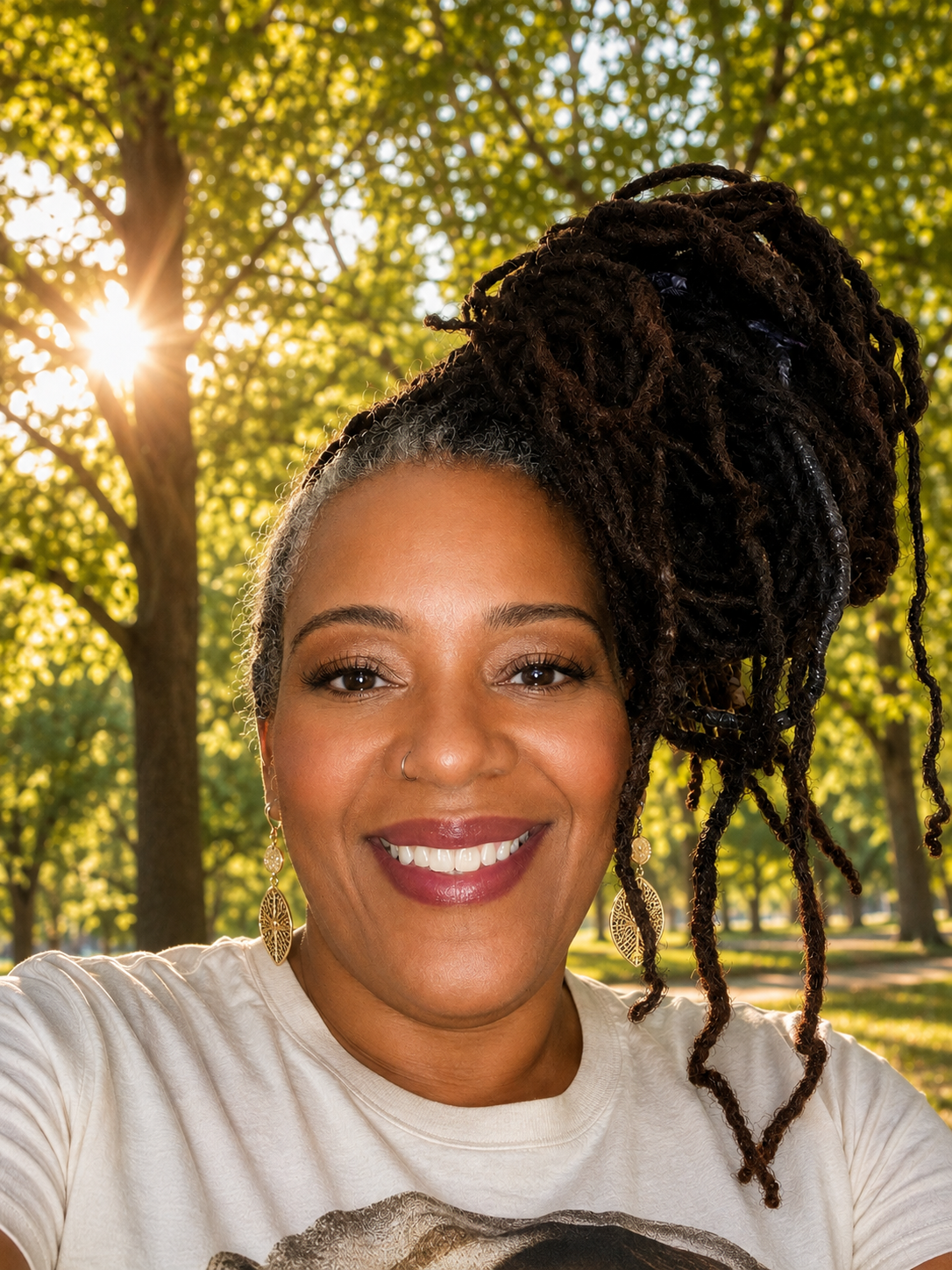 Aliya Banks smiling outdoors in a park during golden hour